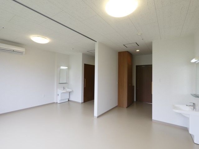 シンプルな白い壁の居室は、広く、明るい雰囲気である。快適に過ごせるよう、個室内はエアコンが完備してある。