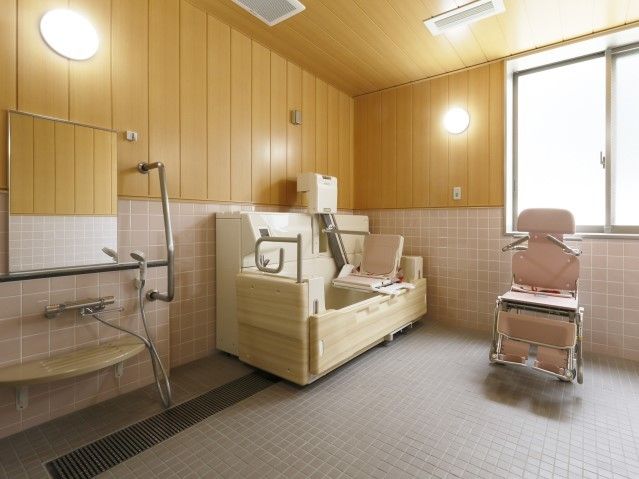 壁が木目調となっており、ゆったりと入浴することができる。介護が必要な方のための入浴設備が完備されている。