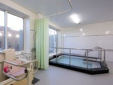 浴槽周辺には複数の手すりが取り付けられている。機械浴槽を導入しており、使用時はカーテンで仕切っている。