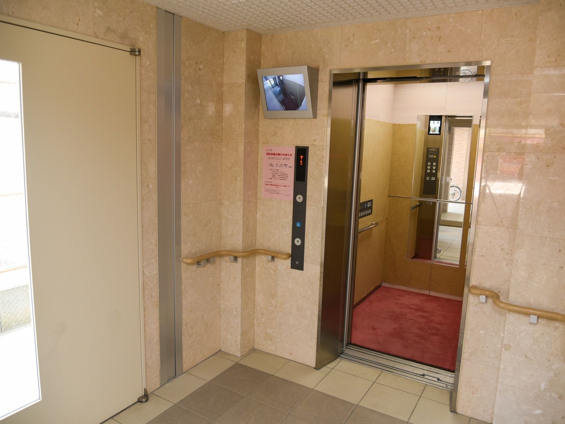 エレベーター内部に手すりと鏡が設けられている。外には防犯カメラの様子を写すモニターが備えられている。