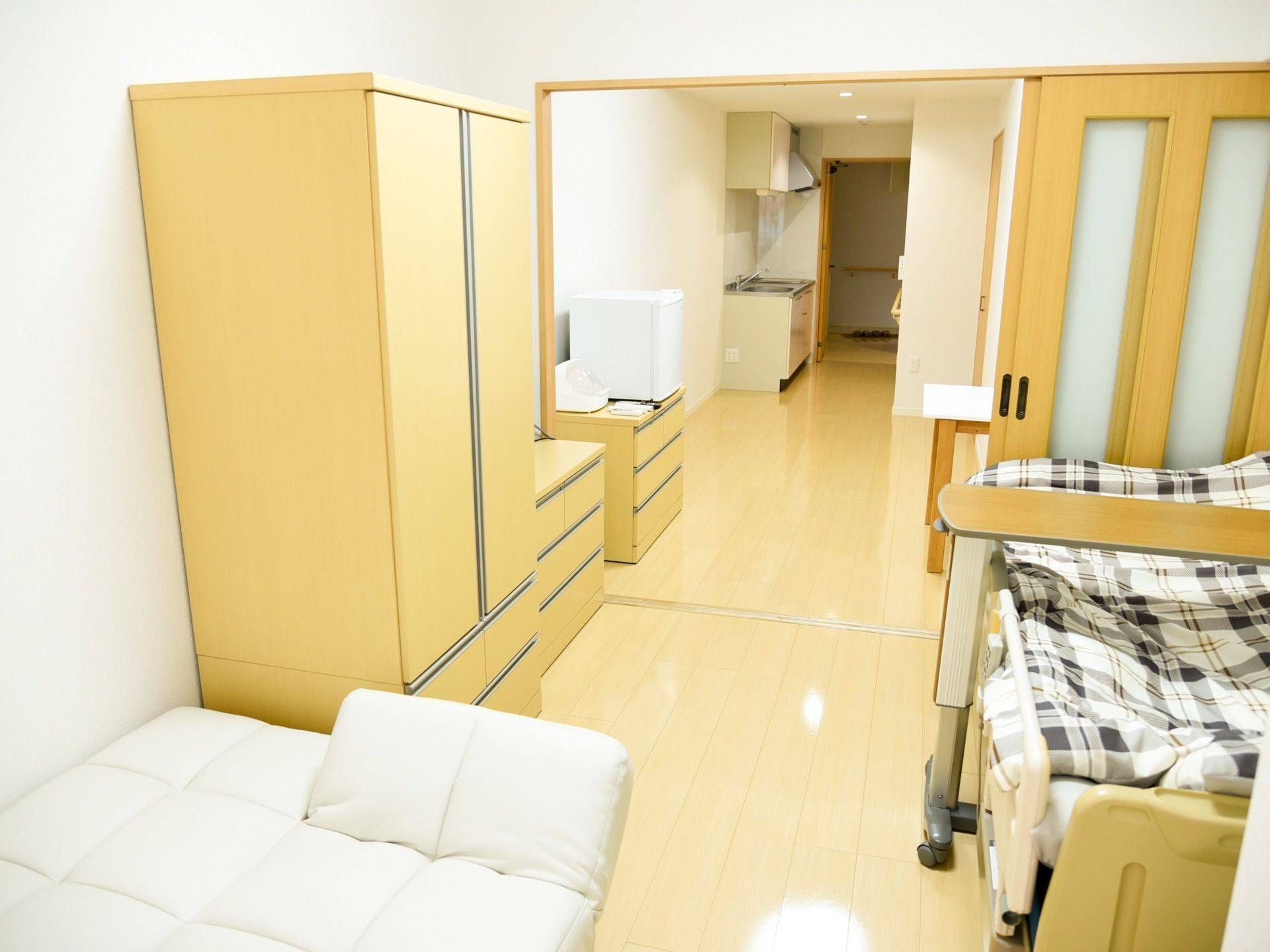 ベッドがある。収納用のタンスやチェストがある。ダイニングキッチンと寝室はスライド式のドアで仕切られる仕組みになっている。