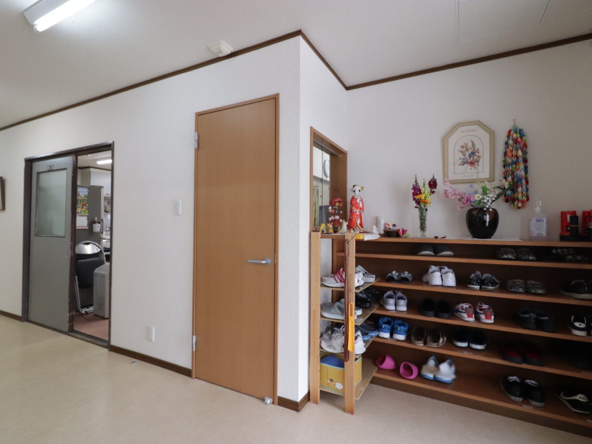 下駄箱には、５列の棚があり、室内履きや来客用スリッパ、外履きを置いておくことができる。棚の上には、花瓶や置物がある。