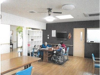 車椅子に乗ったまま利用しやすい、広々したテーブルを設置している。入居者様同士で自由な時間を過ごしている。