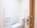 真っ白な洋式便座を備えた、シンプルなトイレである。扉は引き戸式を採用している。手すりや緊急呼び出しボタンも完備されている。