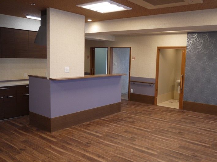 紫色の腰壁の上に天板を取り付けたカウンターを設置してある広間