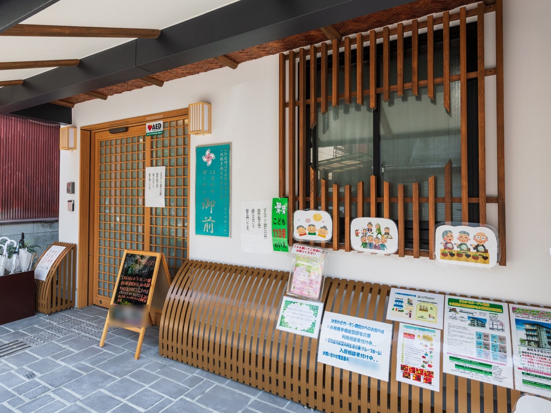 玄関と窓は木の格子戸となっていて、和モダンの風情が漂う。玄関の前には手書きのブラックボードが置かれている。