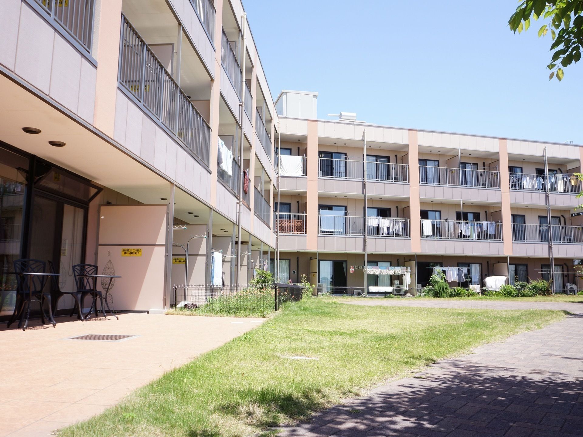 ベランダに洗濯物が干されている居室が所々に見える施設外観