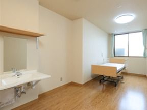 ベッドのほかに、車椅子でも利用しやすい構造の洗面台がある居室