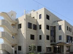 屋根のあるアプローチを設けたマンションのような施設外観