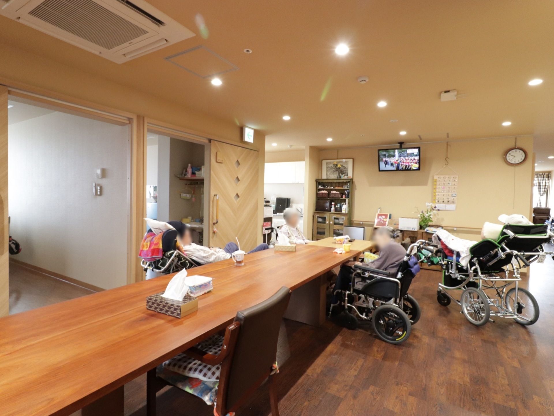 会話やテレビを楽しむことができる広々としたスペースである。ダークブラウンの床で落ち着いた雰囲気がある。