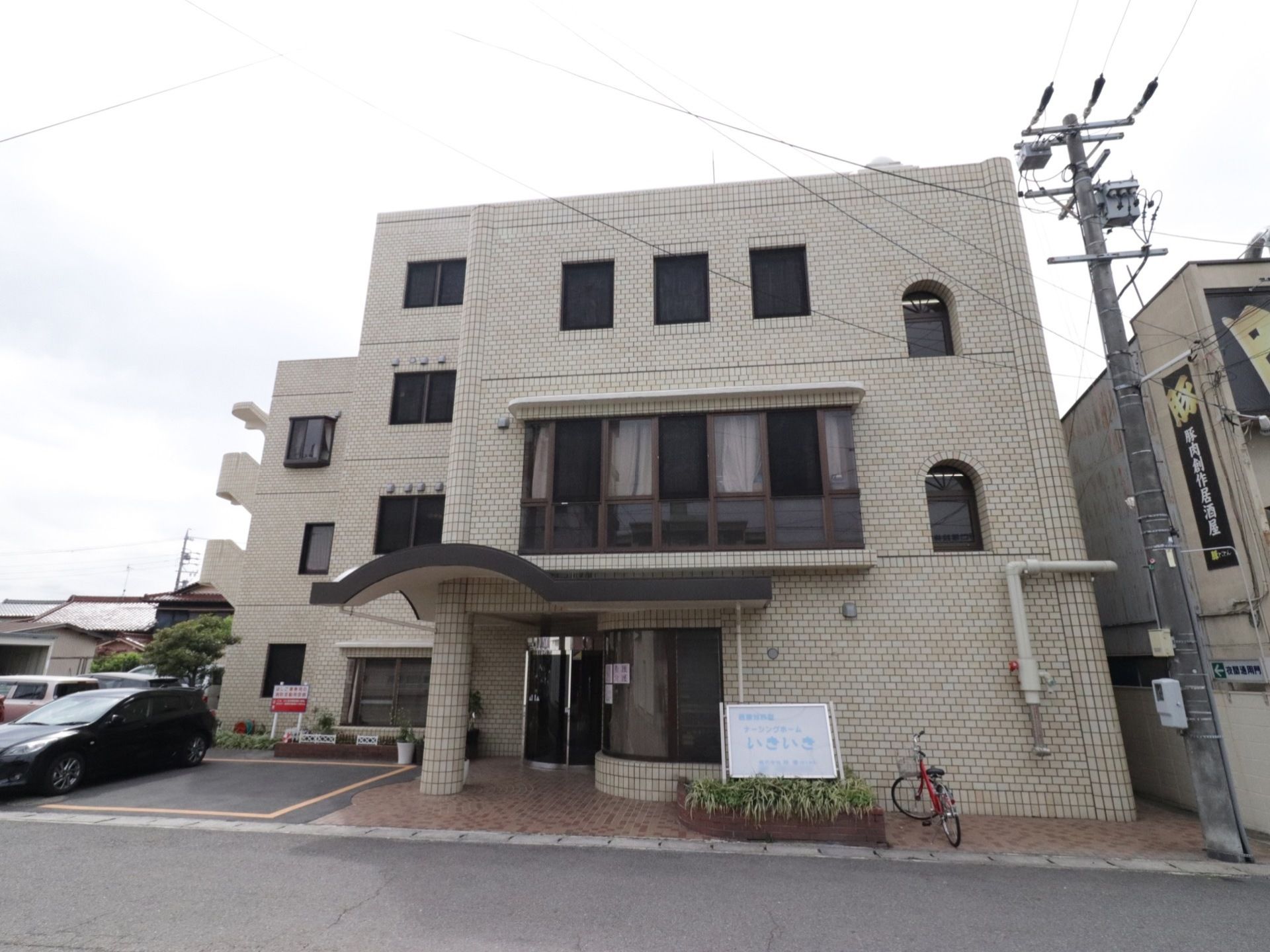 施設は、外壁がベージュ色の大きな建物である。正面には施設名を書いた看板があり、大きな文字でわかりやすく見やすい。
