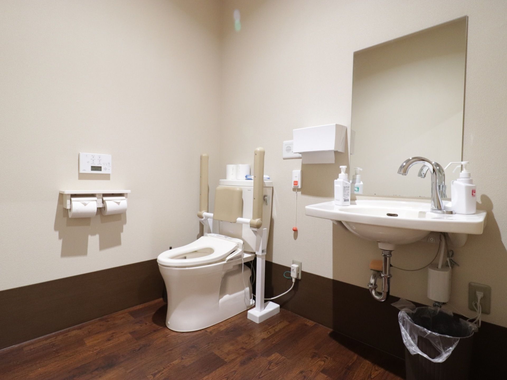 広々としたトイレは、ダークブラウンの床になっており落ち着いた雰囲気がある。呼び出しボタンがあり、緊急時も安心である。