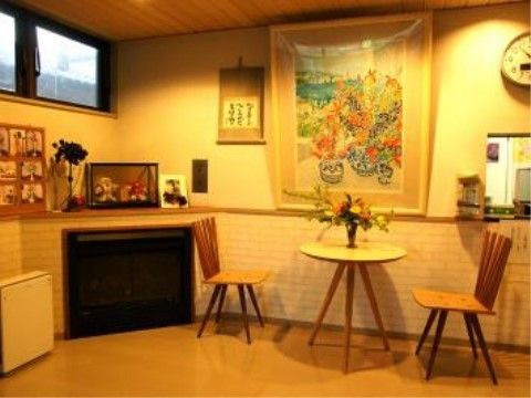 掛け軸や人形、タペストリーが飾られた壁の傍に置かれた、丸テーブルとイス