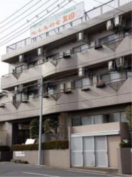 ３階建てのグループホームである。屋上に施設名が書かれた看板が取り付けられており、建物の２階以上の部分にはベランダが設置されている。