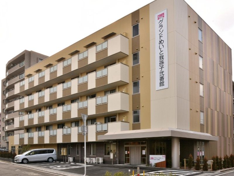 まだ新しい四階建ての、クリーム色の建物である。駐車スペースもある。入口周りには緑も配置され、落ち着ける環境である。