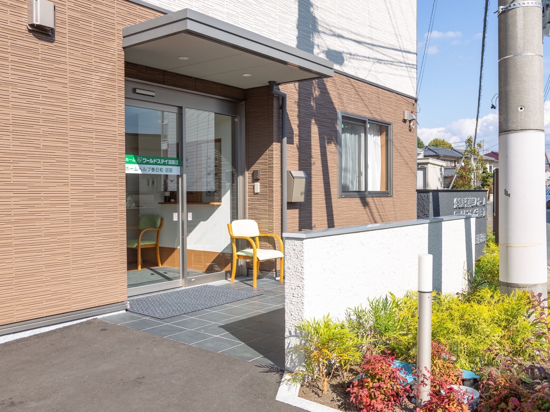 あたたかい日差しが、建物全体を照らしている。自動ドアを完備しており、出入口には背もたれ付きの椅子が置かれている。