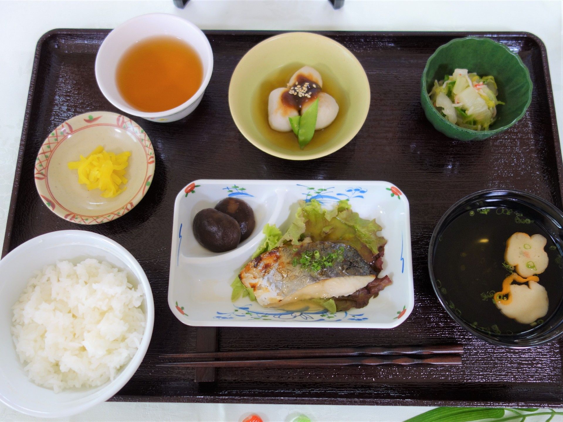 トレーに食事がのっている。メニューはご飯、焼き魚、小鉢、お新香、お味噌汁、お茶である。栄養バランスも考えられており、彩りも良い。