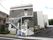 施設の外観は白色とグレー色の配色である。手すりが取りつけられた外階段があり、下には自動販売機が設置されている。
