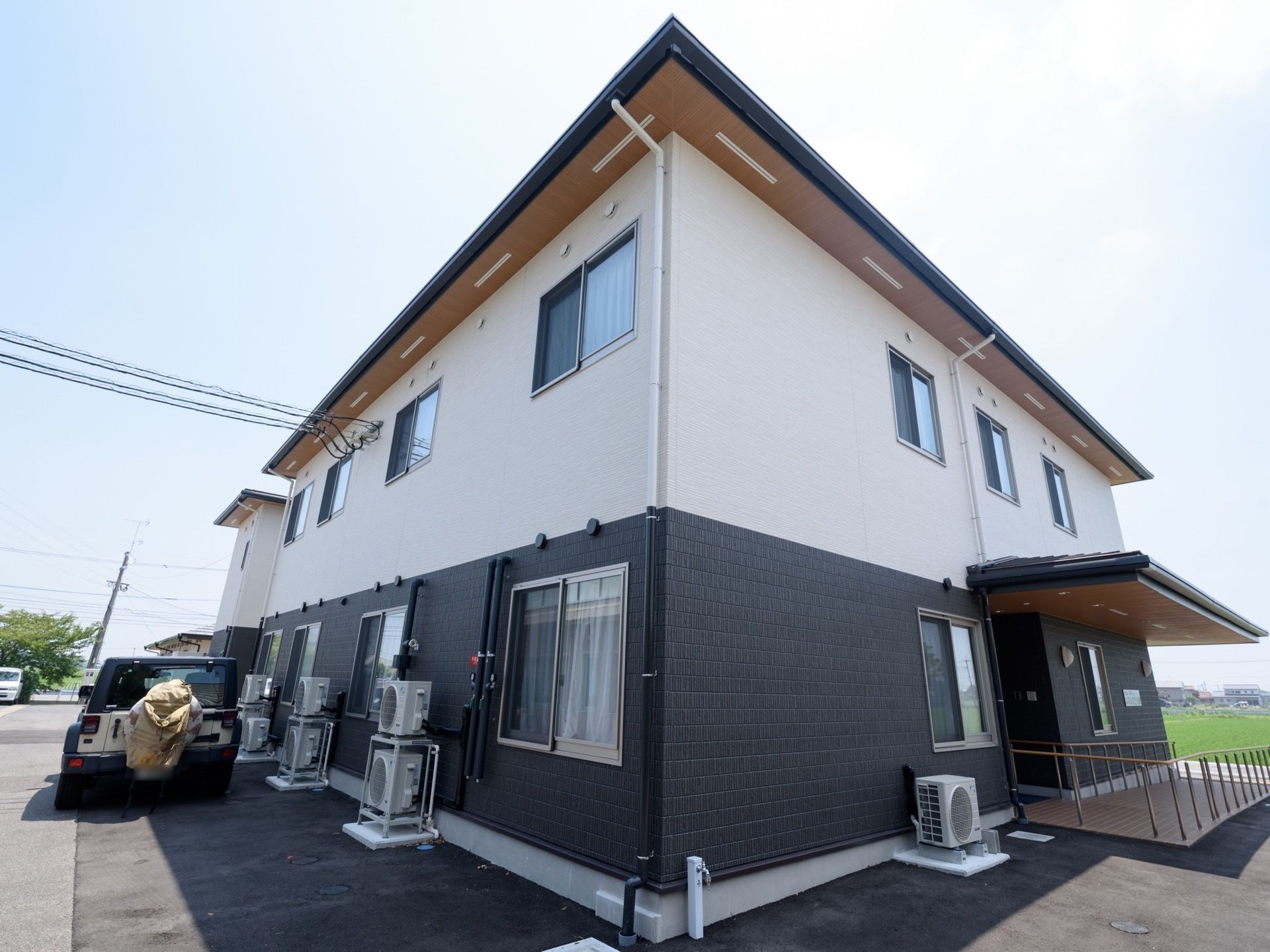 白と濃いグレーのツートンカラーの外壁の、二階建ての建物である。玄関にはひさしがあり、スロープが備わっている。