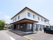 １階は黒色、2階は白色の外壁の2階建ての建物である。玄関には、屋根があり手すりのあるスロープが続いている。