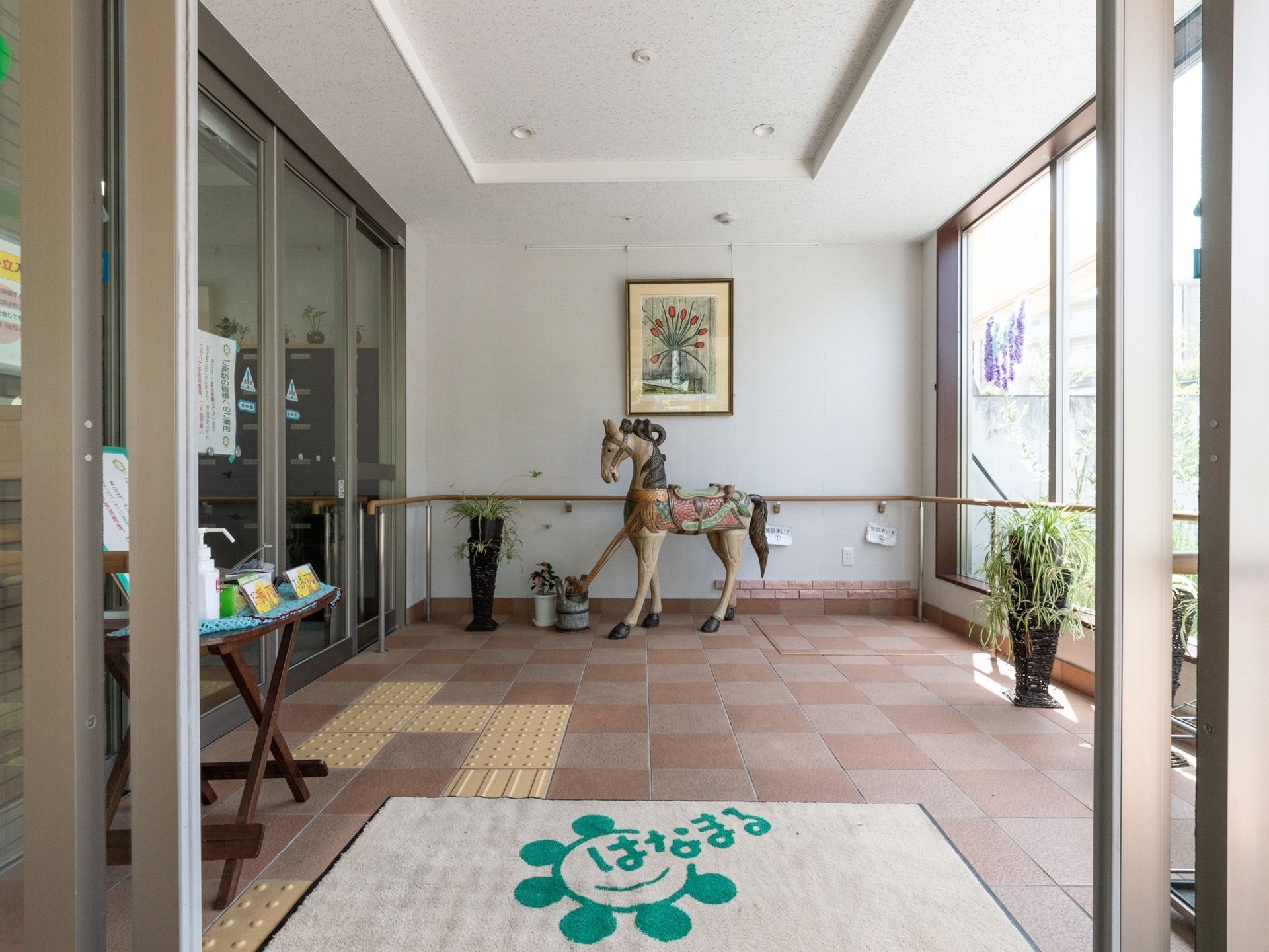 1つ目のドアを入ると日当たりの良い空間がで迎えてくれる。絵画や植物、置物が置かれて落ち着いた雰囲気になっている。