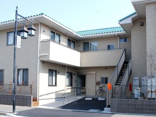 一台の駐車スペースがあり、外に階段があるアパートのような建物