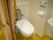 コンパクトなスペースに設置された、壁掛け式のトイレである。ドアは引き戸なので、手の力をあまり入れずに楽に開閉できる。