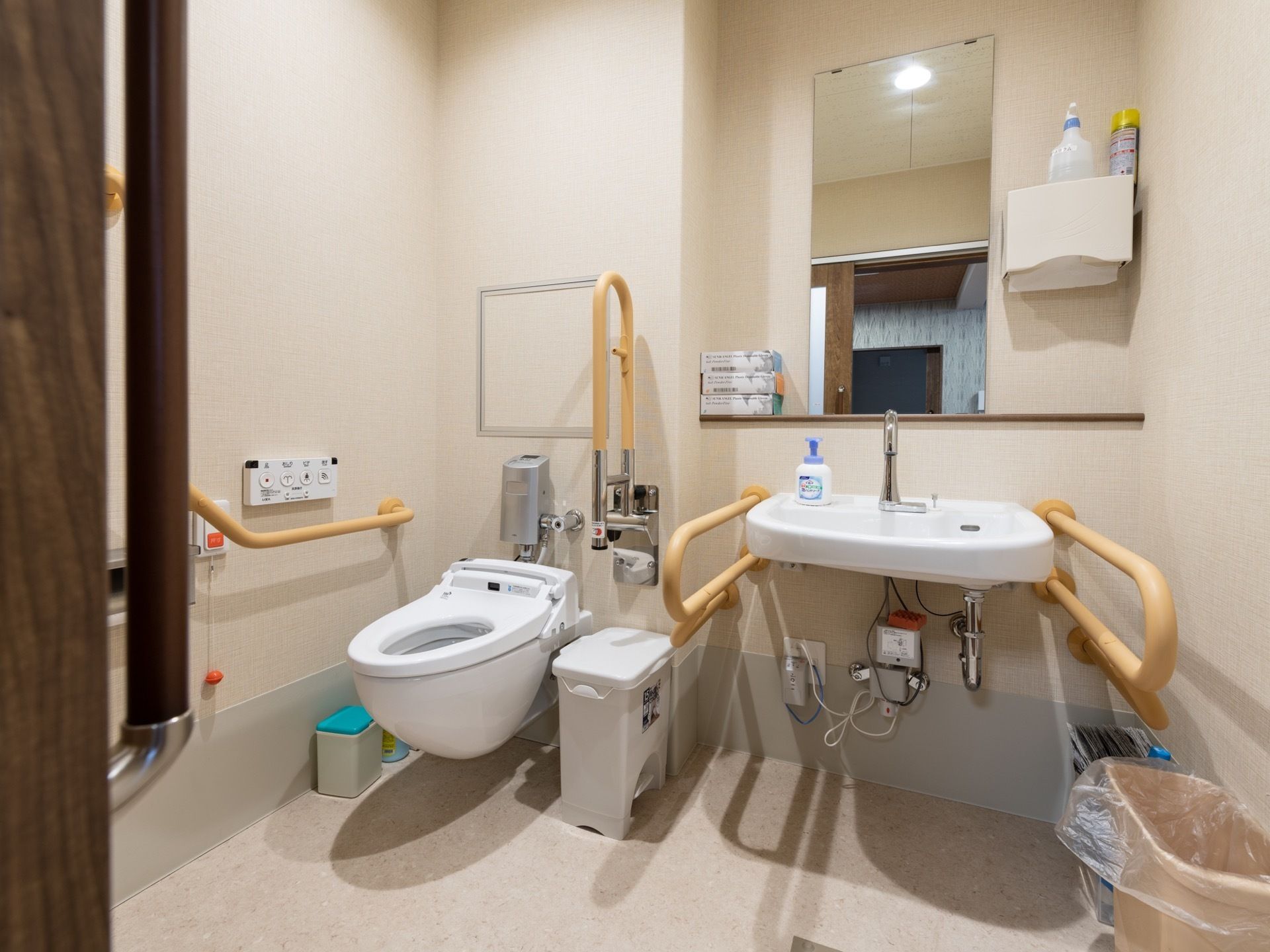 便器の両脇だけでなく、洗面台の両脇にも手すりを設置しており、トイレ内での移動が簡単に行えるよう配慮されている。