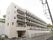 白い壁で5階建てのマンション型施設である。各居室には窓が設置されている。前に建物がないので、採光と通気が抜群である。