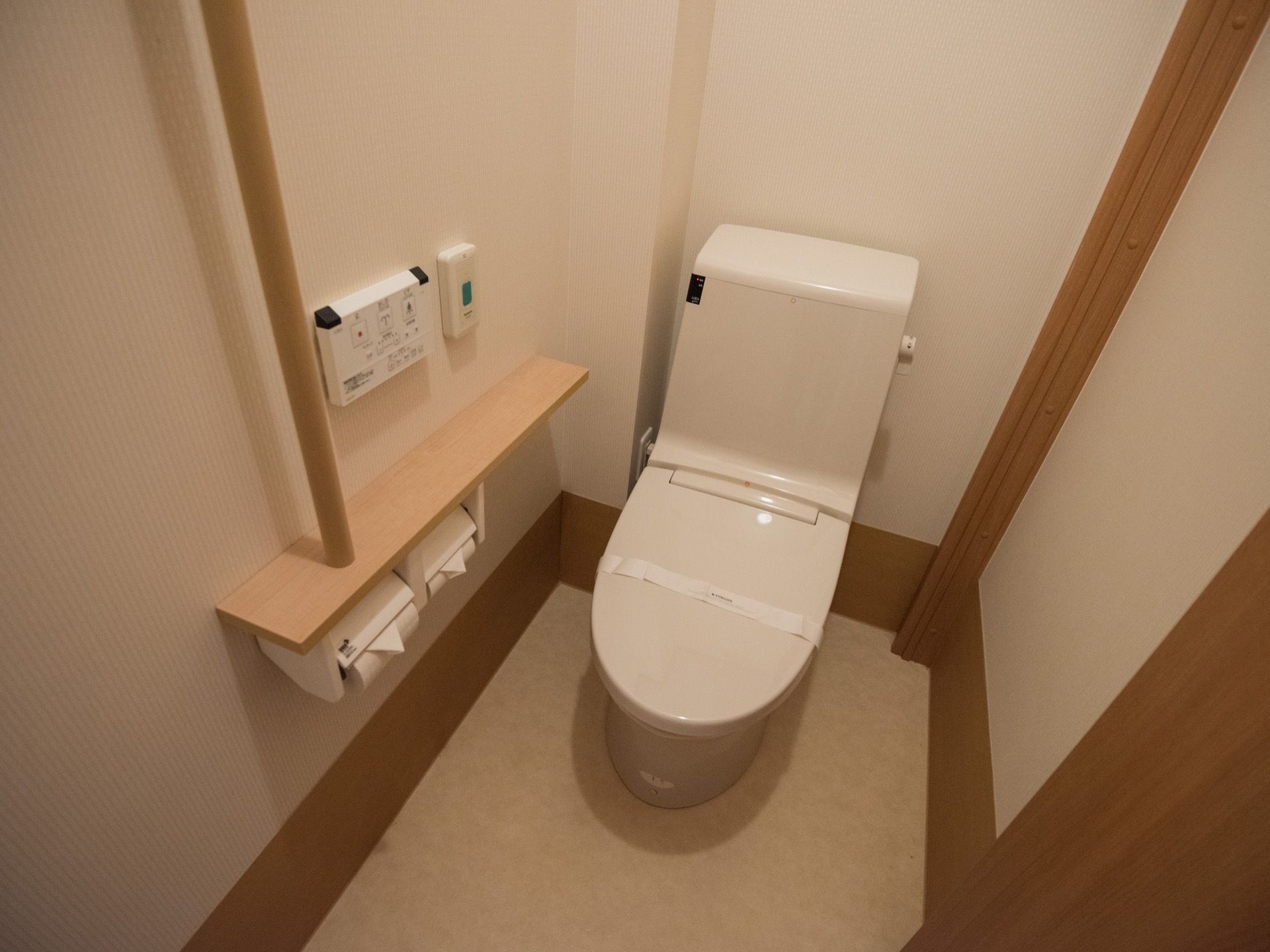 温水洗浄機能付きの洋式トイレがある。扉は引き戸で出入りしやすく、緊急用のナースコールが設けられている。