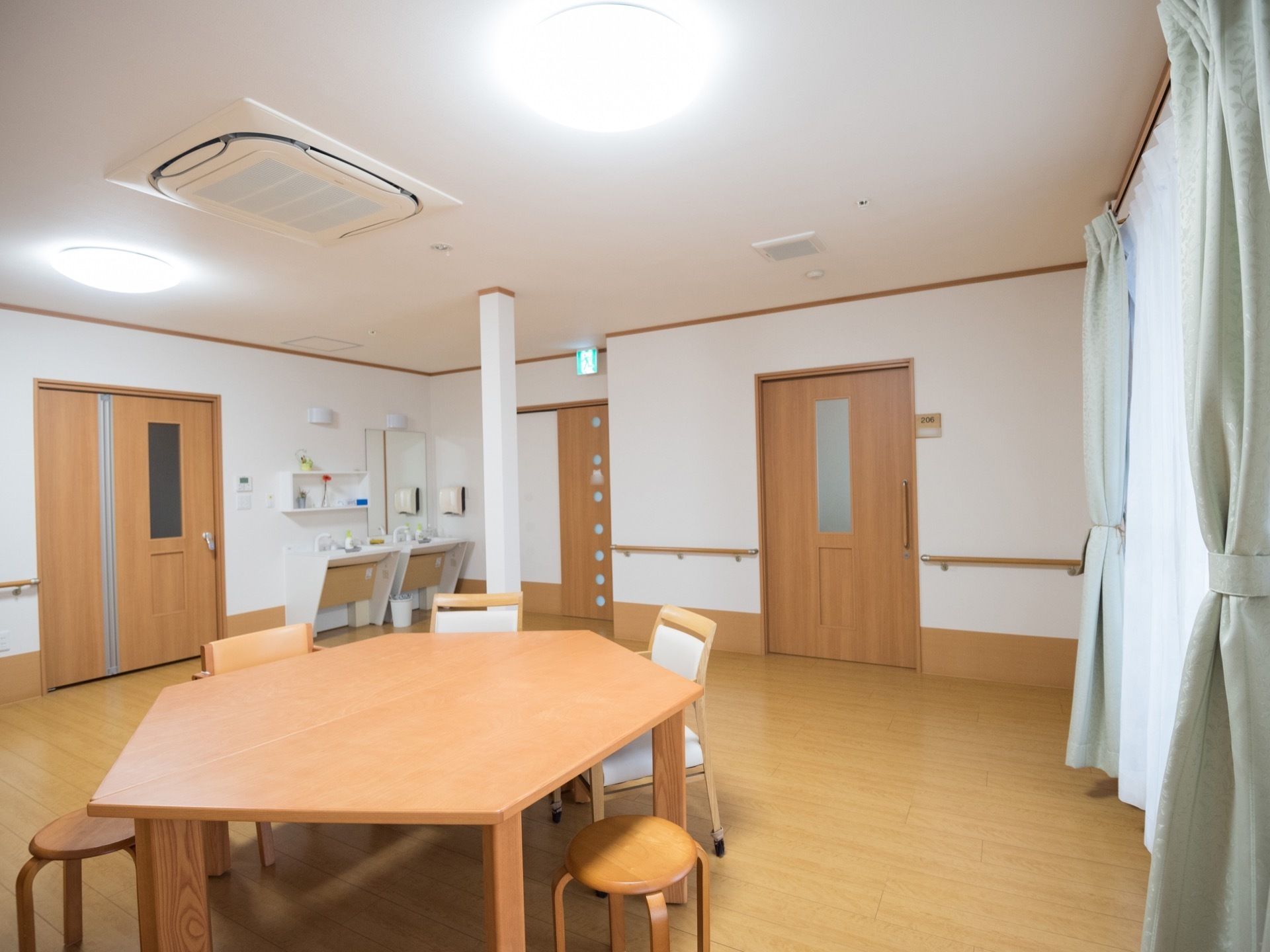 空調のついた広いフロアに木製のテーブルが置かれている。テーブルは六角形で、丸椅子や背もたれ付きの椅子などもある。