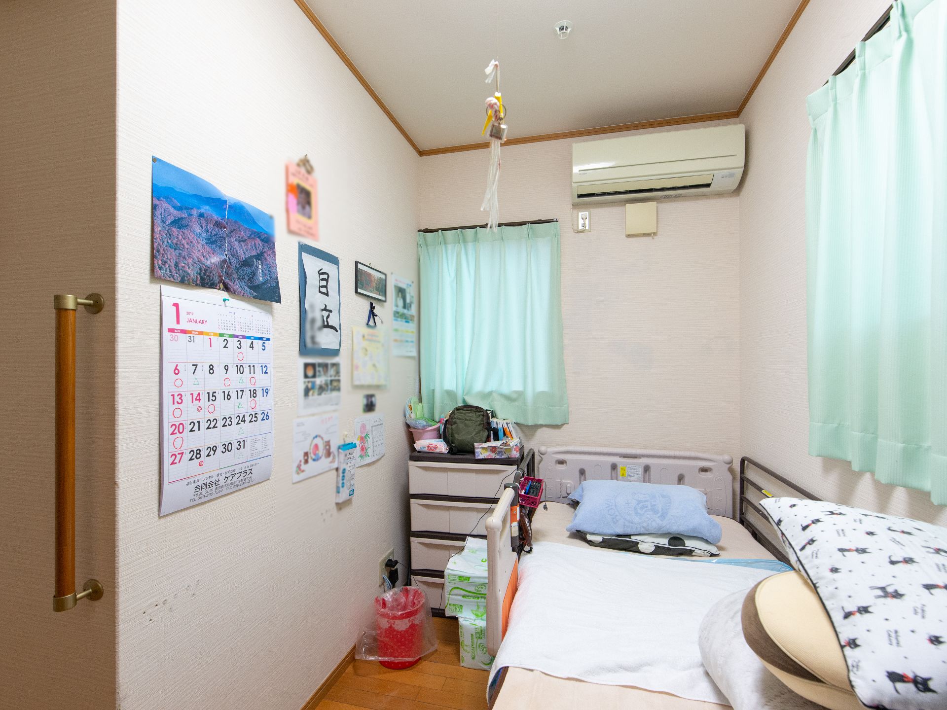長方形にレイアウトされている居室。窓が2つ設置されている角部屋である。ベッド、収納ボックスが置かれている。