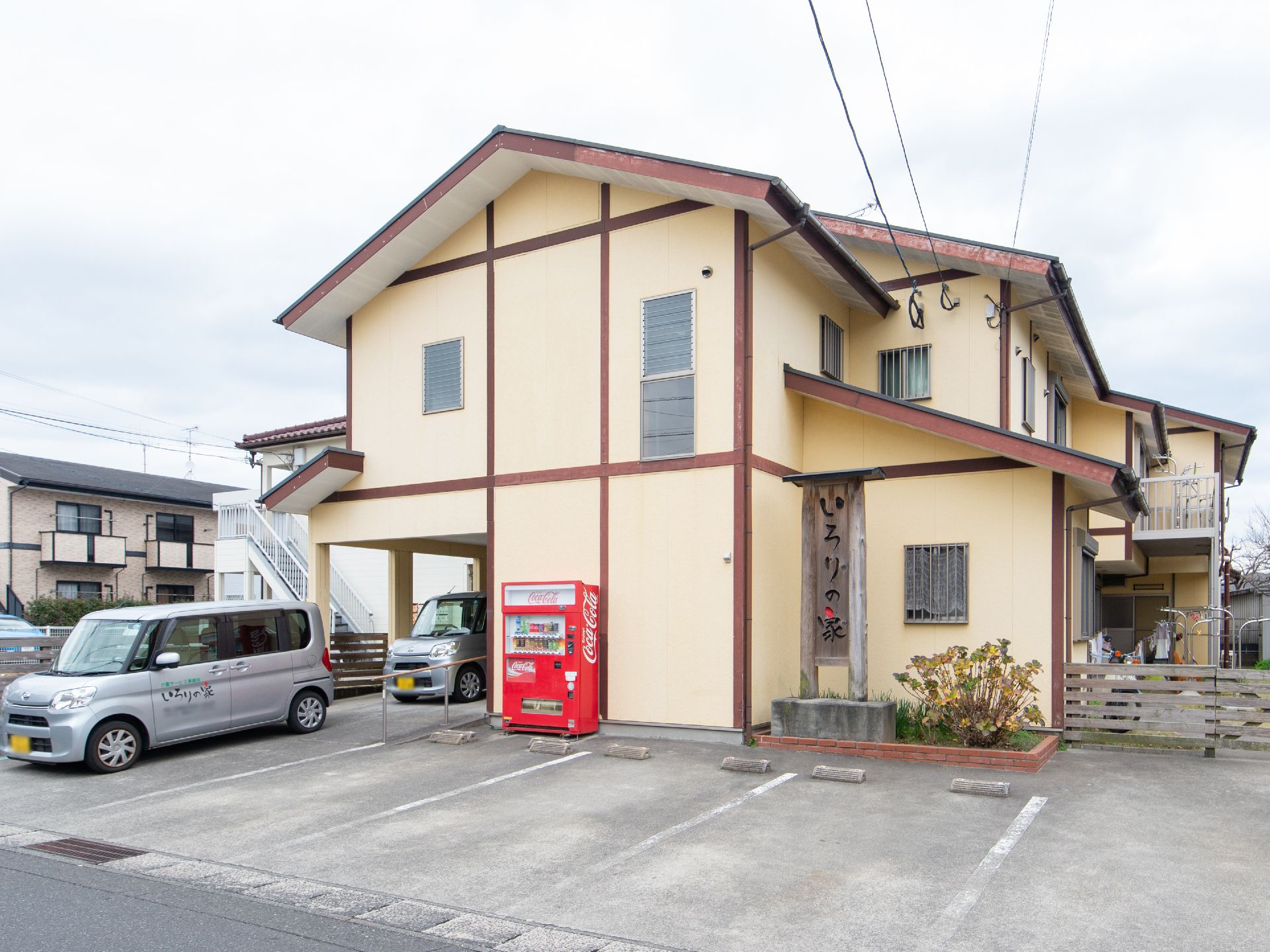 閑静な住宅地に立地している施設の外観は、二階建ての民家風である。建物の前に駐車スペースが設けられている。