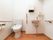 トイレはとても広いスペースを設けている。壁には手すりが設置され、便器脇の手すりに緊急通報装置が取りつけられている。