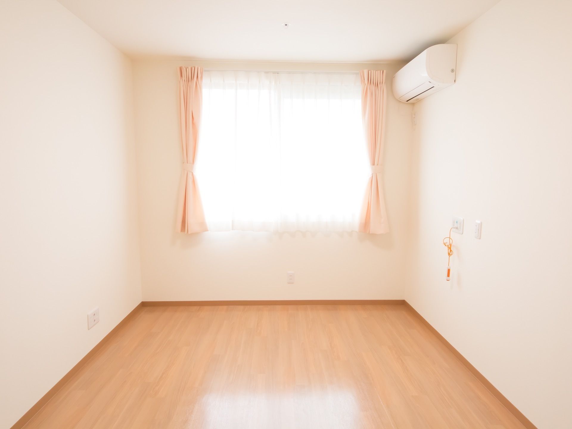 入って正面に窓のある居室。淡いカラーのフローリングと白い壁からなるシンプルな内装だ。ナースコールを配備している。