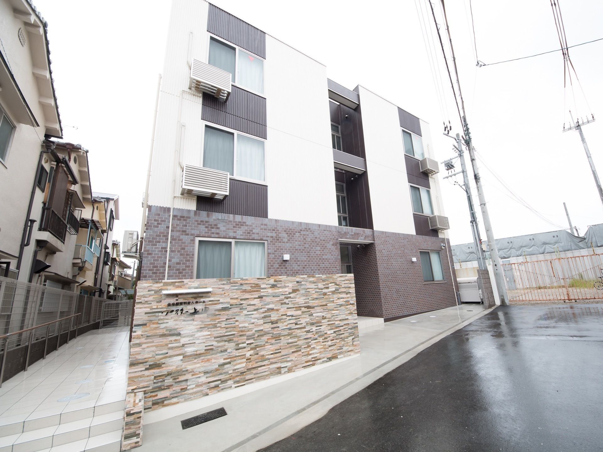 ブラウンとホワイトで施工された、３階建てのシックな建物である。四角形タイプの現代的なデザインが印象的。