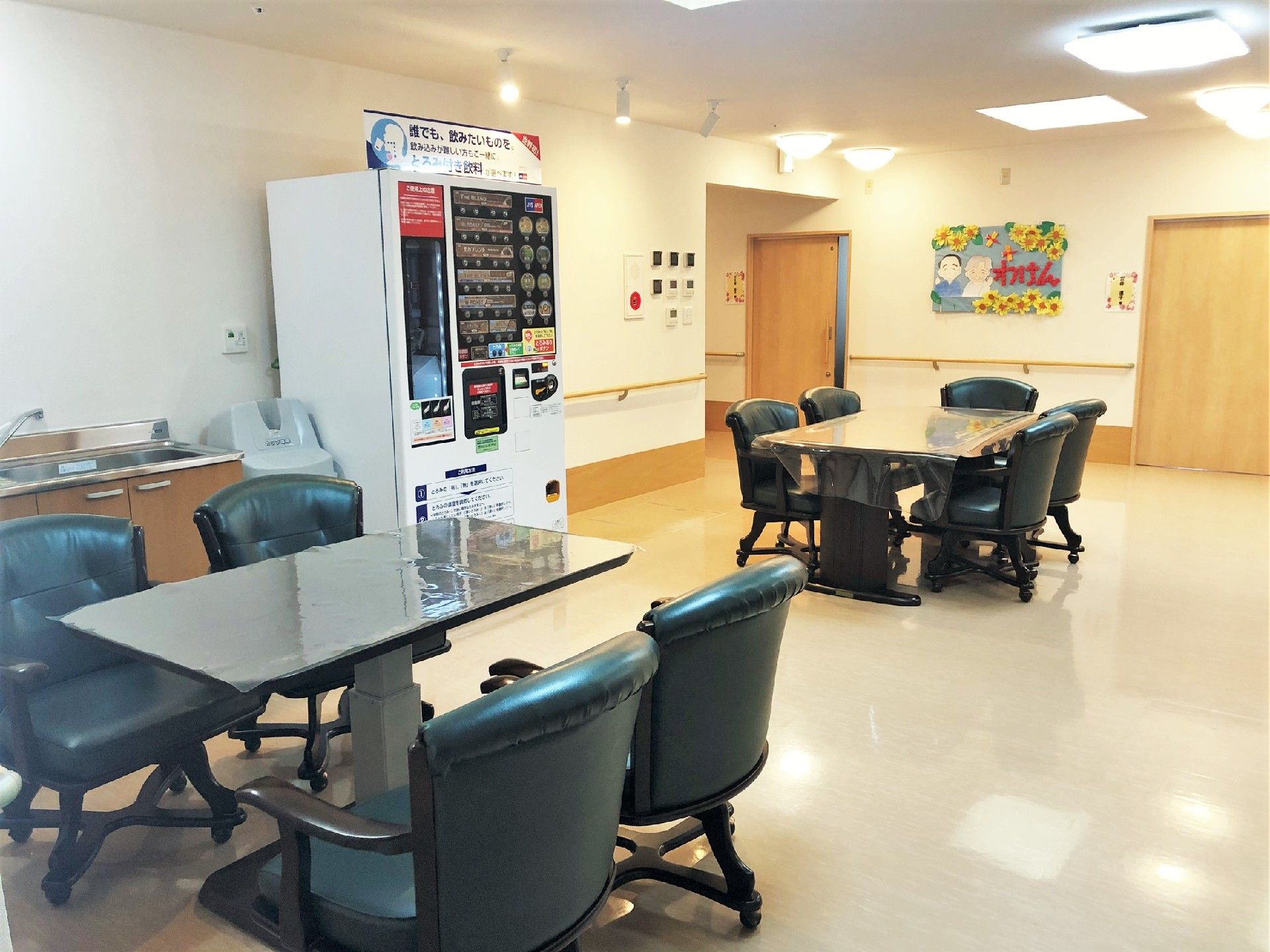広々とした開放的な空間になっている。花が飾られた６人掛けテーブルが用意されている。壁に沿って手すりが設置されている。