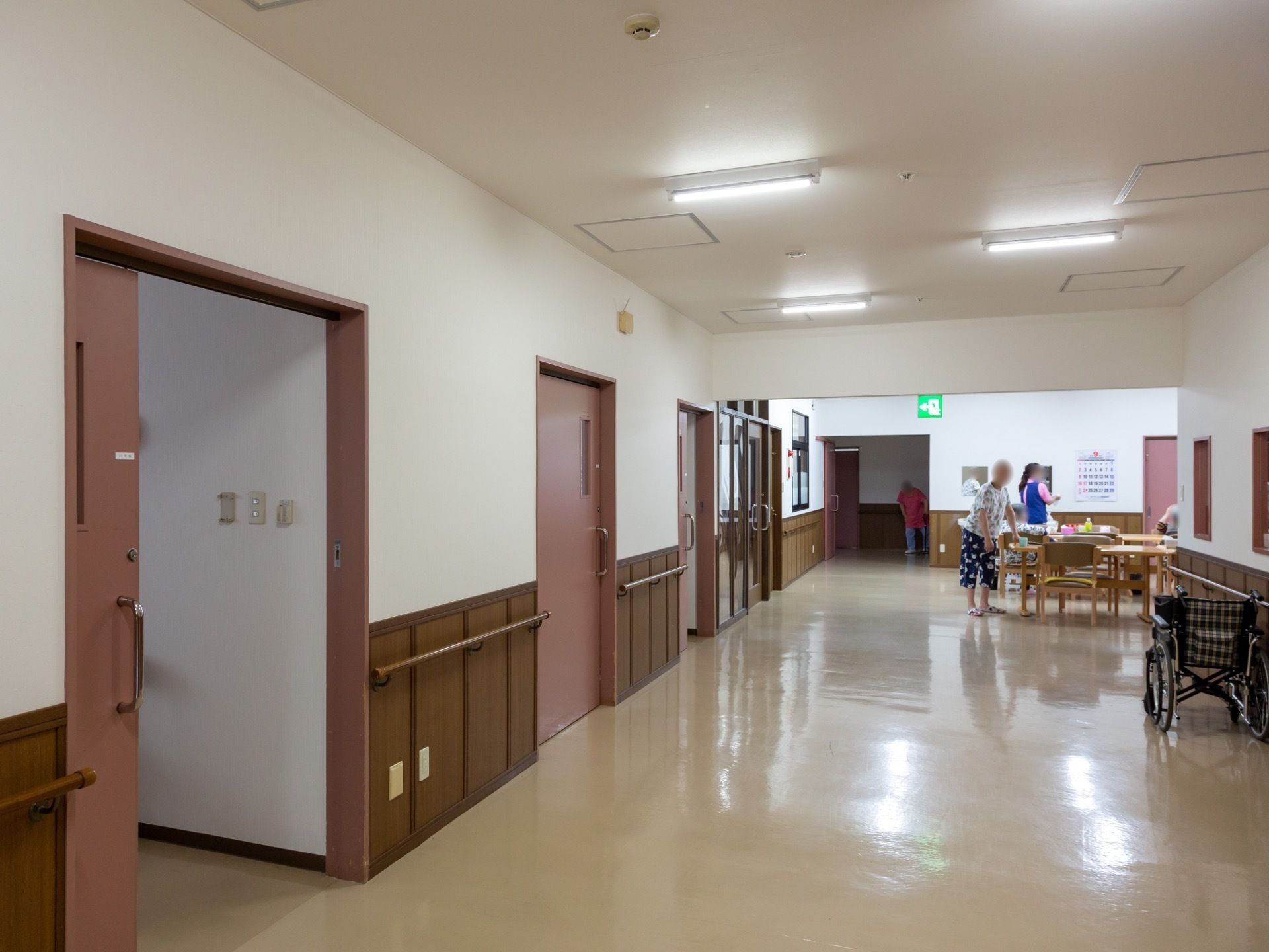 食堂へと続く廊下には入居者様の居室が並んでいる。車椅子をご利用の方が不便にならないよう広く造られ、複数ですれ違っても歩行を妨げることがない。
