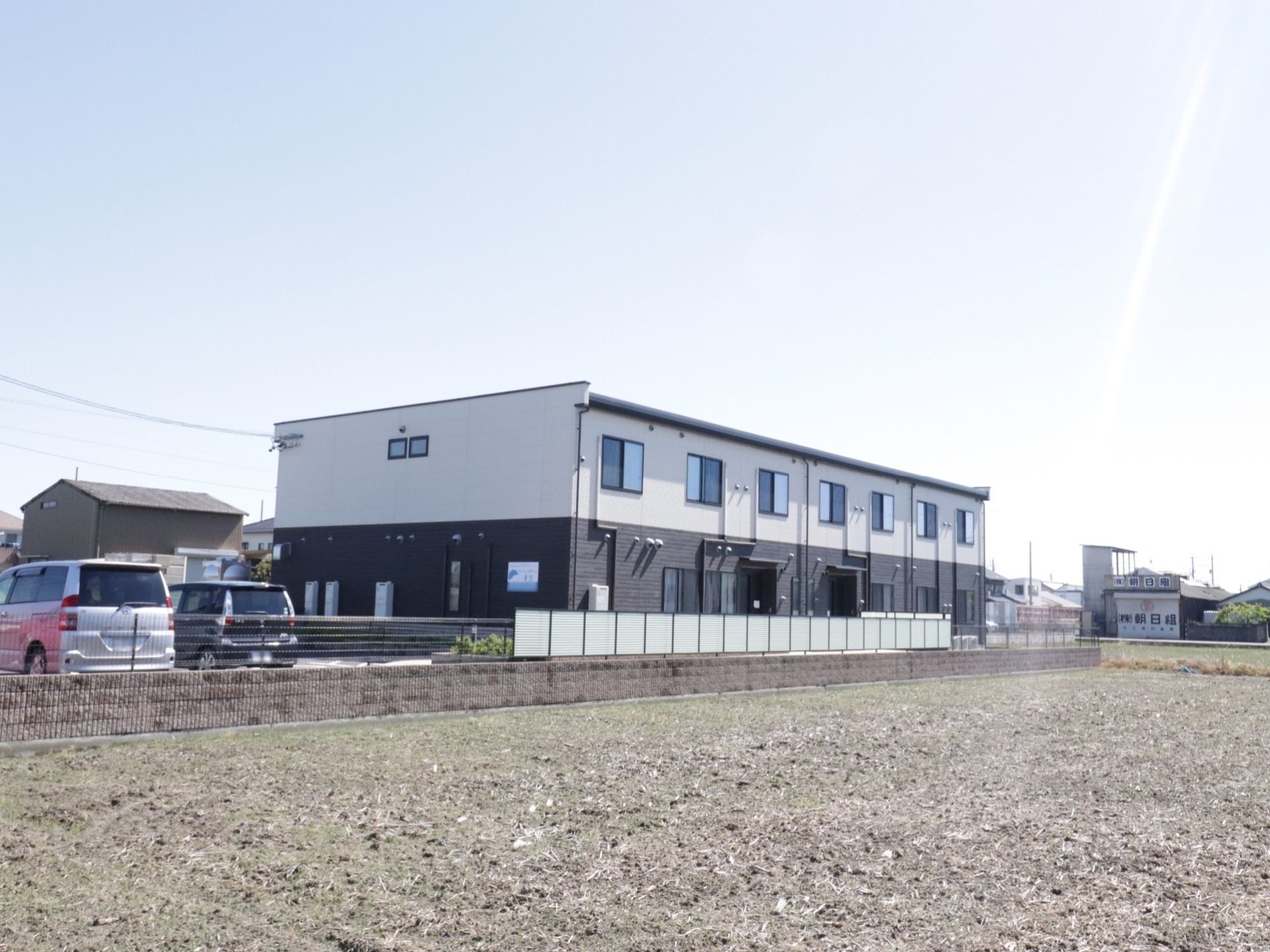のどかな環境の中に建っている２階建ての施設である。建物横に駐車場が設けられており、敷地はフェンスで囲まれている。