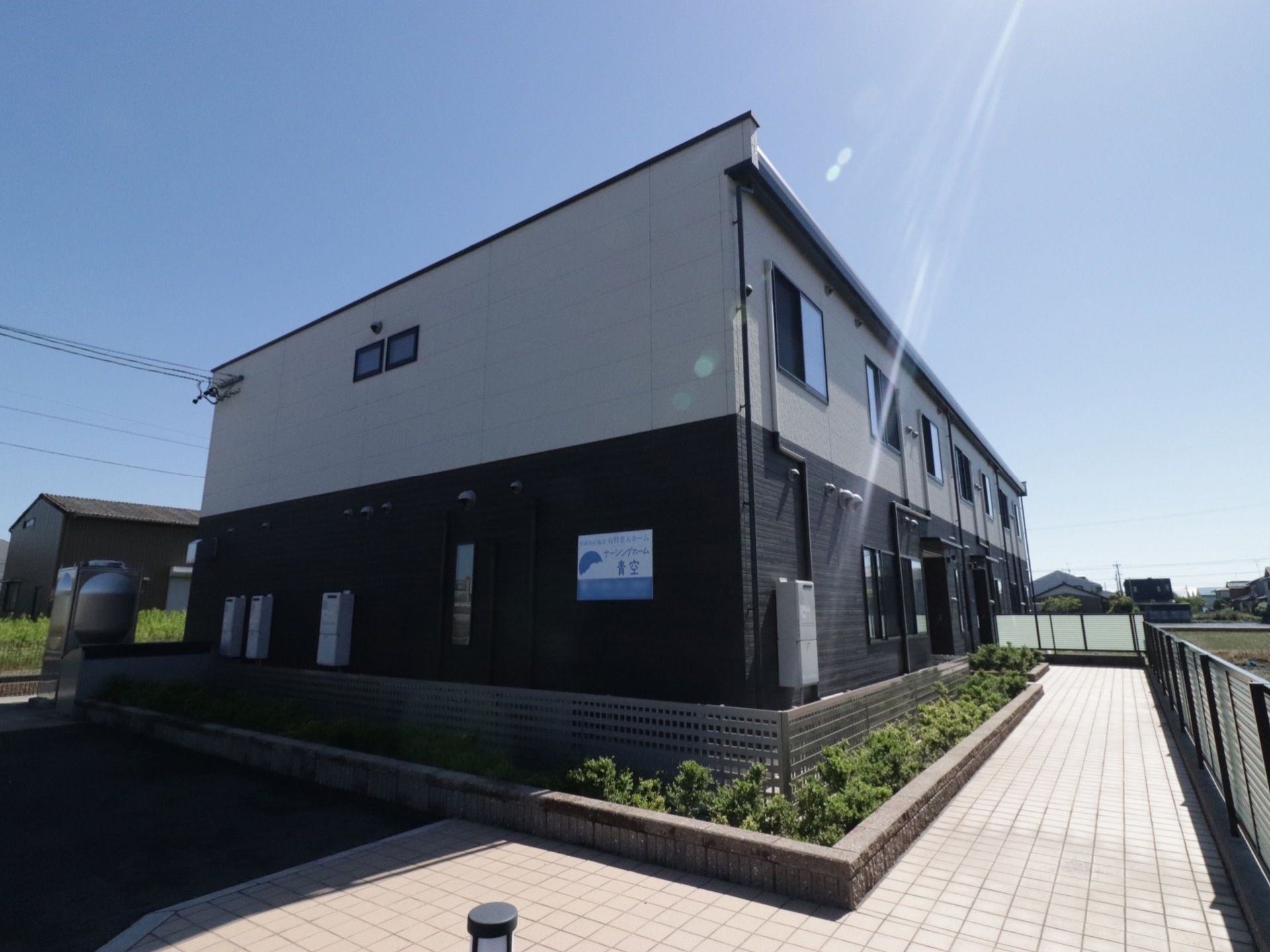 施設は白と黒のツートンカラーの２階建てである。エントランス部分には、緩やかな傾斜が付いている。建物に沿って花壇が設置されている。