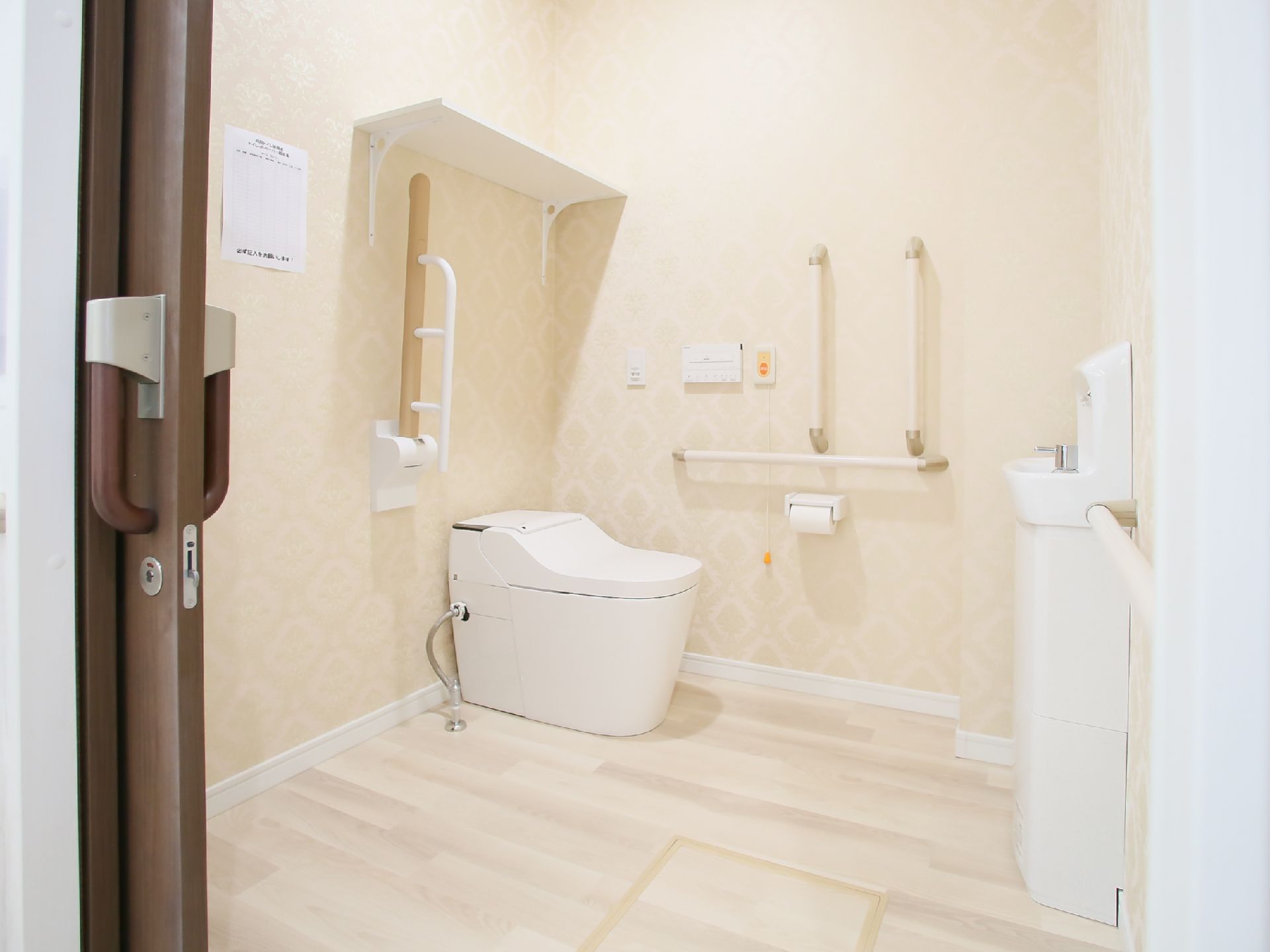 清潔感のある明るいトイレである。出入口の扉はスライド式になっており、安全に開け閉めすることができる。