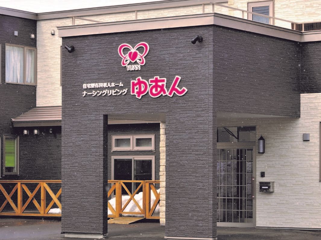施設の外観である。玄関前は屋根が付いている部分があり、吹き抜けになっている。上方の壁に、施設名が表記されている。