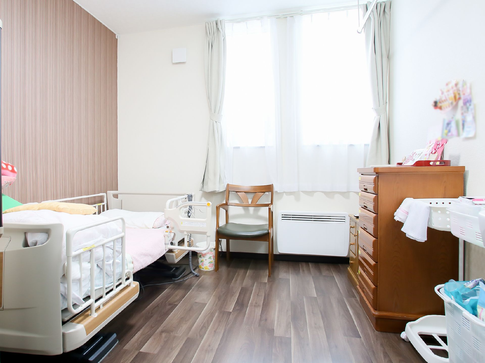 明るく広々として清潔感のある室内。家具を壁に寄せて配置しているので、部屋の中央は通路として広く空けられている。