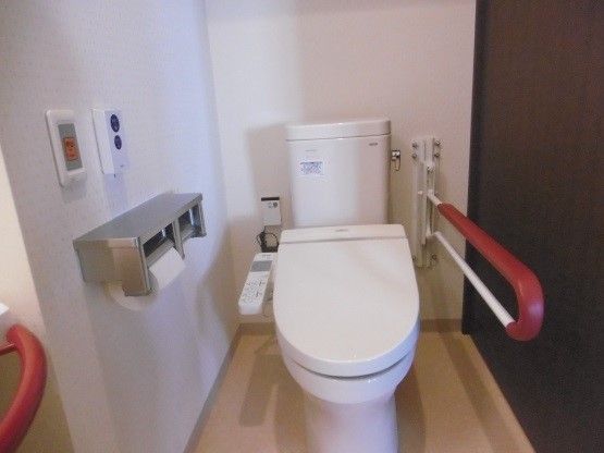 車椅子からの移動に便利な、可動式の手すりが設置されたトイレである。個室内にナースコールを備えており、緊急時にスタッフに連絡することができる。