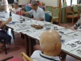レクリエーションの一環として書道を楽しむ複数の入居者様