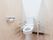 トイレの両サイドの壁と床はベージュ色である。壁に２つ並んだペーパーホルダーがあり、上に物が置けるようになっている。