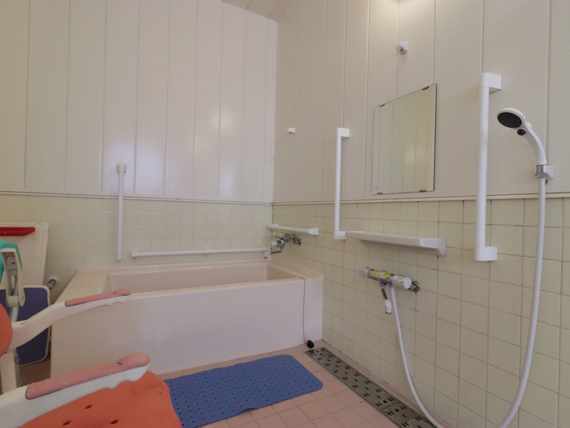 浴室には、専用の椅子が置かれており、シャンプーなどの使用にも不便がない。鏡の下には、小棚も設置されている。