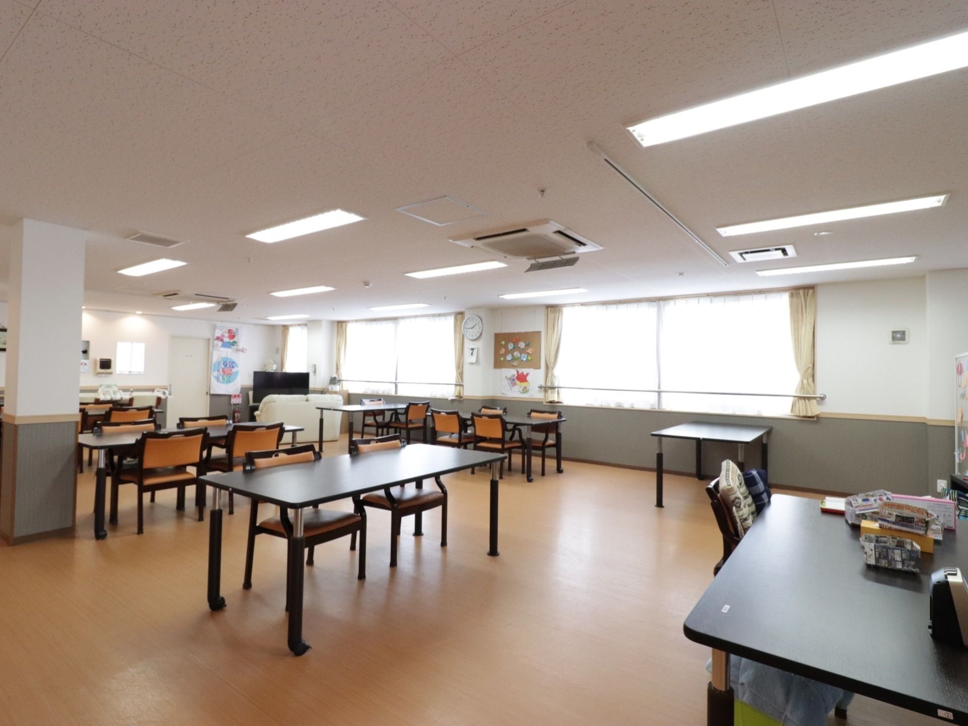 テーブルや椅子が複数用意されている。室内の角にはテレビが設置されており、テレビの前にはソファーが置かれている。