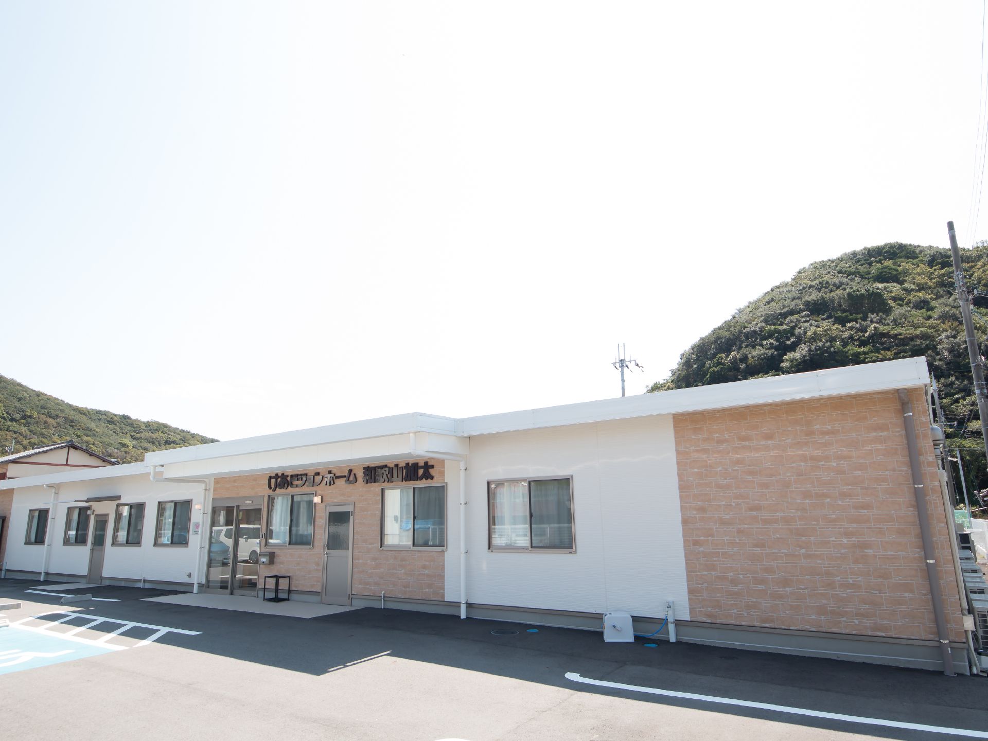入口付近の壁に大きく施設名が書かれた平屋建ての施設建物