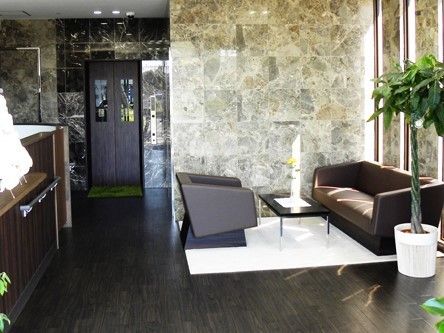 床はダークカラーのフローリングで、ドアや収納棚も同系色で揃えられている。壁際には観葉植物が飾られている。
